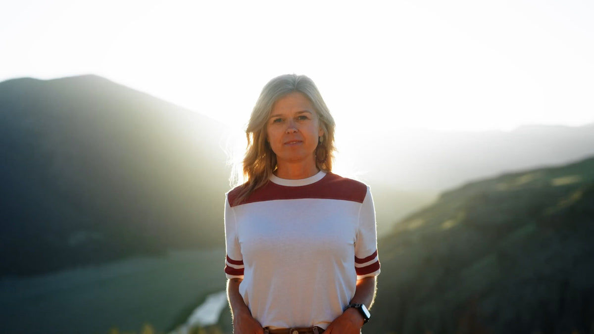 Courtney, Skeyo founder, standing in the Colorado mountains at golden hour