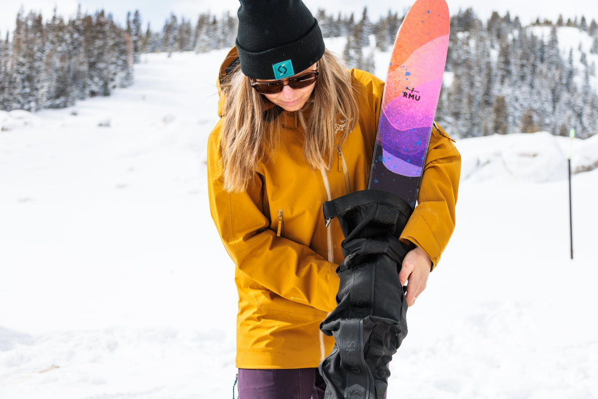 Skier sliding skis into a Skeyo Ski Bag in the snow